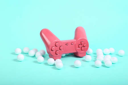 Pink gamepad with white balls on blue background. Minimalism still life. creative layout