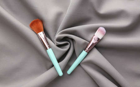 Makeup brushes on a gray silk background. beauty still life.の写真素材