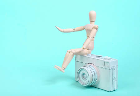 wooden puppet with camera on blue backgroundの写真素材