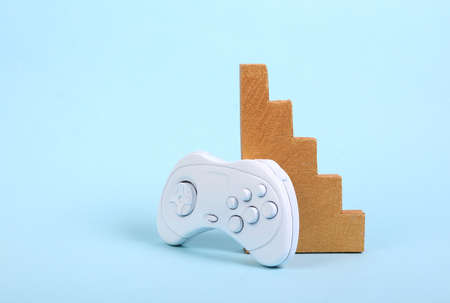 video game tournament. Gold geometric staircase and gamepad on a blue background. minimalismの写真素材