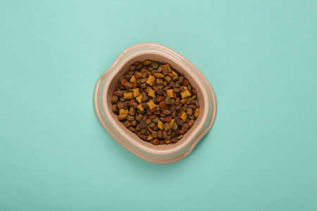 Plastic bowl with cat food on blue background. top viewの写真素材