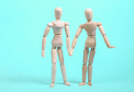 Loving couple of puppets hold hands on a blue background. love, romantic concept