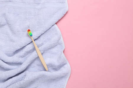 Eco-friendly bamboo toothbrush with towel on pink background. copy spaceの写真素材