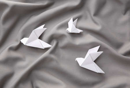 Origami doves on gray silk backgroundの写真素材
