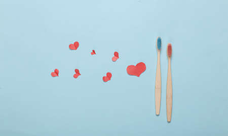 Eco bamboo toothbrushes and hearts on blue background. Romantic, love conceptの写真素材