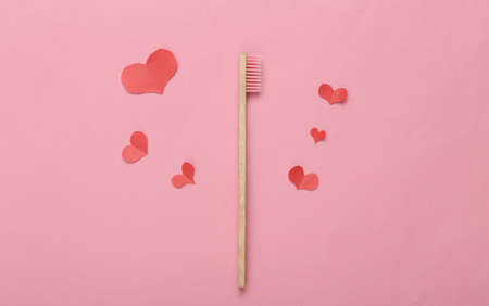 Eco bamboo toothbrush and hearts on pink background. Romantic, love conceptの写真素材