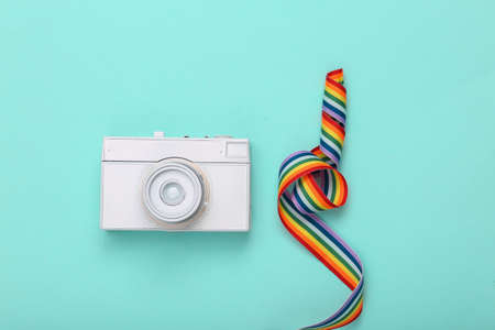 White painted camera and rainbow tape on blue background. minimalismの写真素材