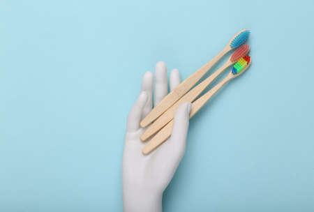 Hand holding Toothbrushes on a blue background.
