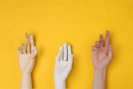 Different hands on a yellow backgroundの写真素材