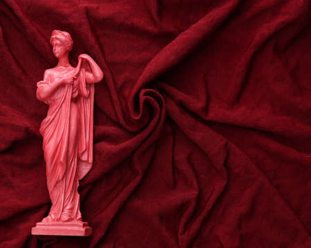 Antique pink statue on red silk background. beauty conceptの写真素材