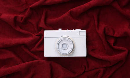 White camera on red silk background. minimalismの写真素材