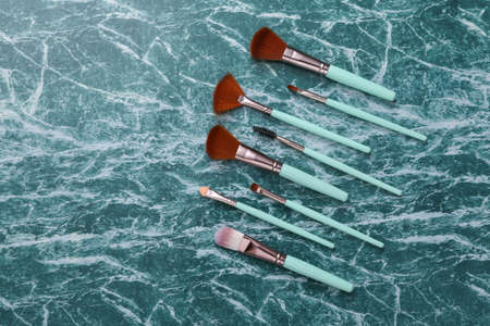 Makeup brushes on blue marble surface. beauty products