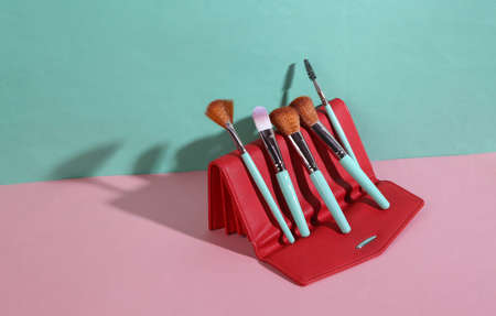 beauty and fashion minimalist scene. Makeup brushes and purse on blue pink pastel background with trendy shadows. creative layoutの写真素材