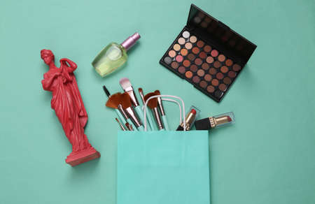 Beauty accessories in shopping bag and antique beauty statue on blue background