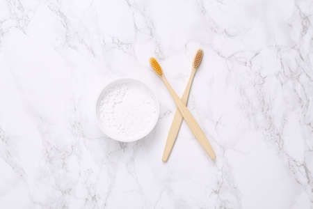 Eco-friendly bamboo toothbrushes and tooth-powder on marble background. top view.の写真素材