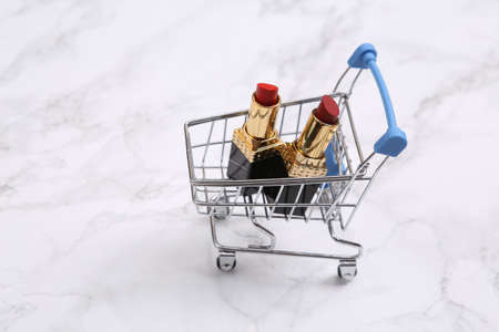 Shopping cart with lipstick on marble backgroundの写真素材