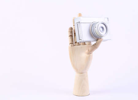 wooden hand holding camera on white backgroundの写真素材