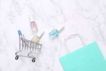 Shopping bag with Nail Polish Bottles and shopping bag on Marble Surfaceの写真素材
