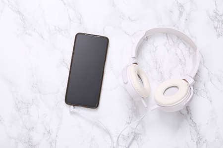 Smartphone and headphones on marble surfaceの写真素材
