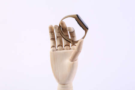 Wooden hand holding smart bracelet on white background