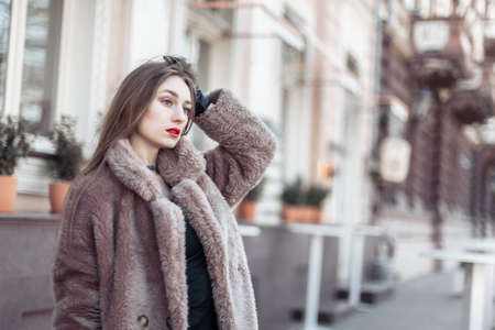 Fashion woman in a luxurious fur coat in the city