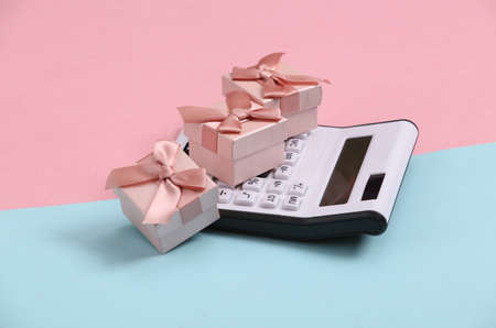 Calculator with gift boxes on pink blue background.の写真素材
