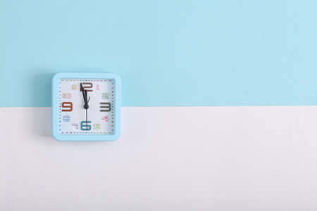 Square alarm clock on white blue background. top view
