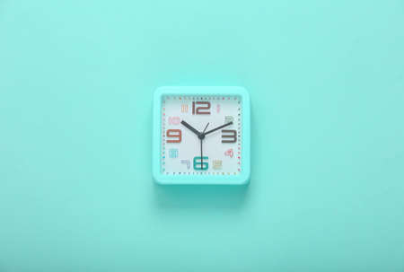 Square alarm clock on a blue background. top viewの写真素材