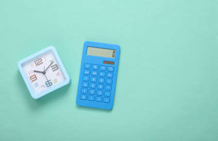 Calculator and alarm clock on blue background. top viewの写真素材