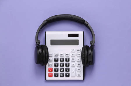 Calculator with stereo headphones on purple background. top viewの写真素材