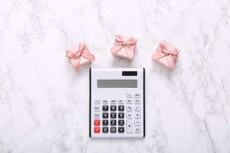 Calculator and gift boxes on a marble surface. top viewの写真素材