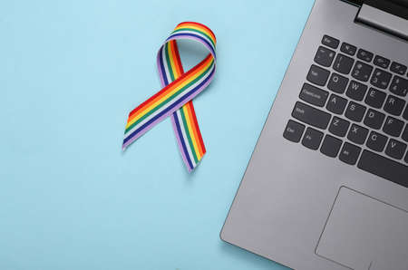 Laptop and LGBT rainbow ribbon pride tape symbol on blue background. love conceptの写真素材
