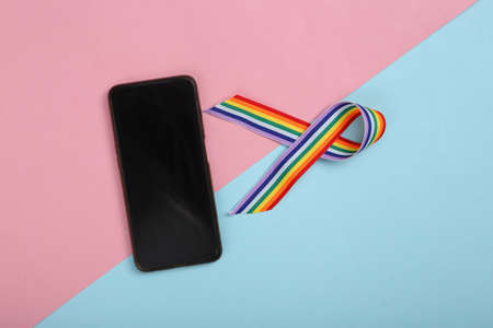 LGBT rainbow ribbon pride tape symbol with smartphone on pink blue background.
