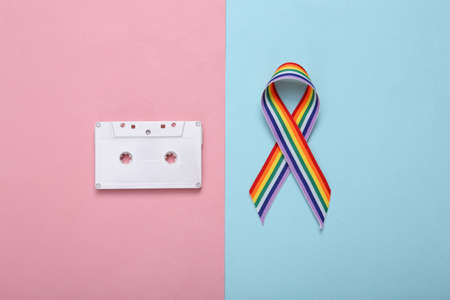 LGBT rainbow ribbon pride tape symbol with audio cassette on pink blue background.の写真素材