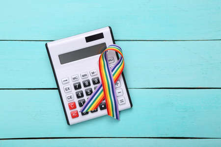 Calculator with lgbt symbol rainbow ribbon on blue wooden backgroundの写真素材