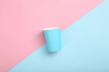 Empty blue cardboard coffee cup on pink blue background. minimalismの写真素材
