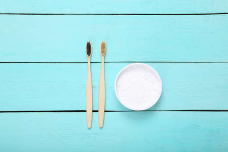 Eco bamboo toothbrushes with tooth powder on wooden table