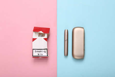 Tobacco heating system and pack of cigarettes on pink blue background. Alternative smoking