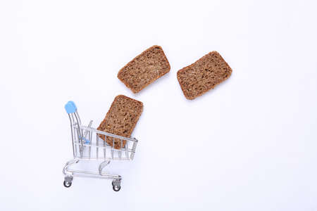 Shopping trolley with Sliced whole grain rye bread on white background