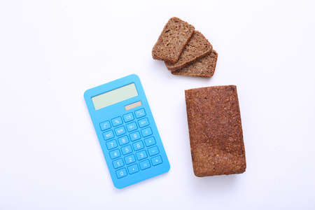Calculator with Sliced whole grain rye bread on white background. Diet, calorie counting conceptの写真素材