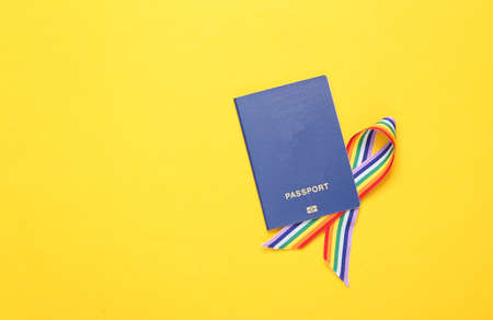 Passport with LGBT rainbow ribbon pride tape symbol on yellow background. top viewの写真素材