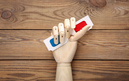 Wooden hand holds 3d glasses on wooden backgroundの写真素材