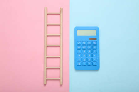 Wooden ladder and calculator on a blue-pink pastel background. Concept of economics, career growthの写真素材