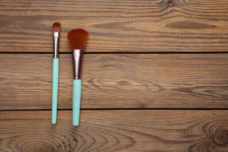 Two makeup brushes on a wooden backgroundの写真素材