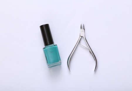 Metal nail pliers and nail polish bottle on white background. beauty still lifeの写真素材