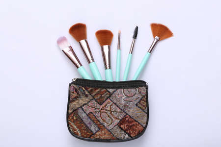 Cosmetic bag with makeup brushes on white background. top viewの写真素材