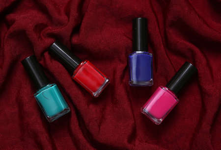 Bottles of nail polish on red silk backgroundの写真素材