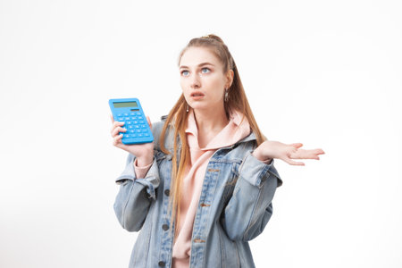 Puzzled woman student with calculator isolated on white backgroundの写真素材