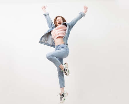 Cheerful energetic woman jumping isolated on white background.