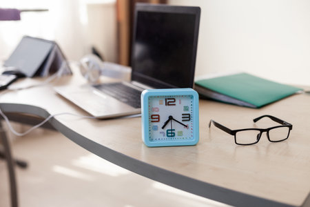 Alarm clock close up on table with workspaceの写真素材